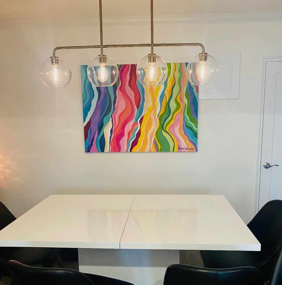 A finished rainbow canvas hanging in a Brooklyn dining room
