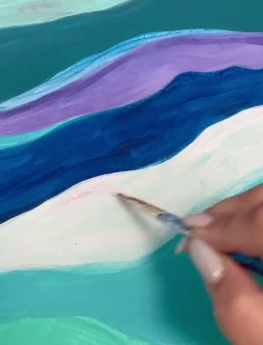 Waves being painted in pink and teal